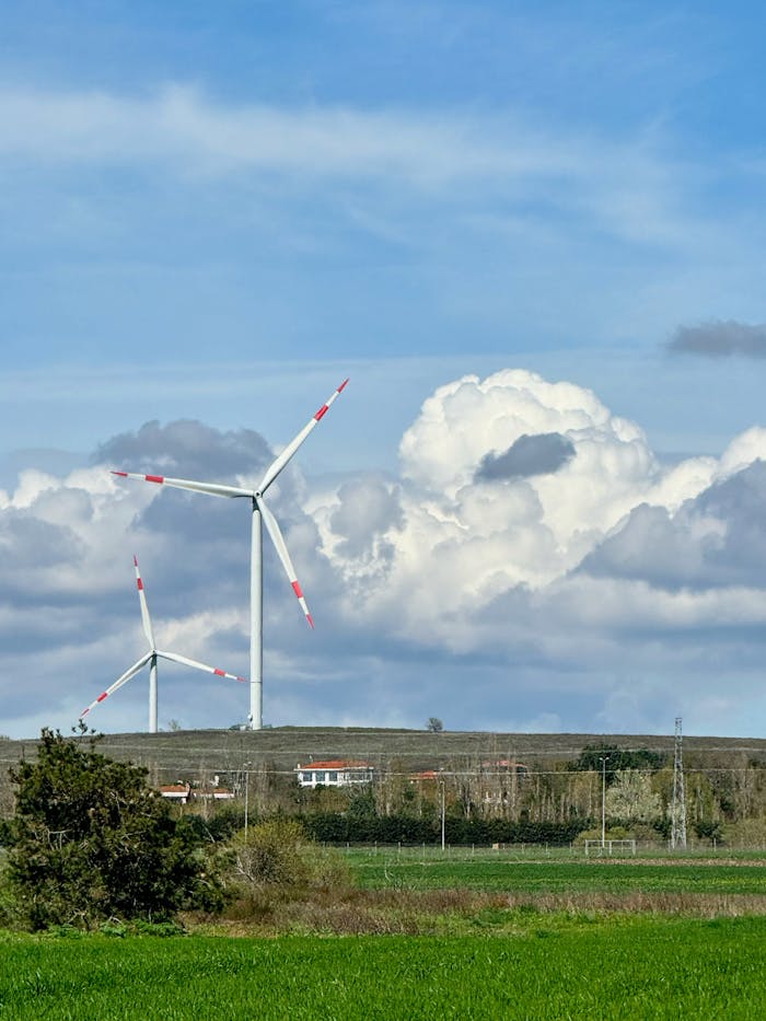 services-hero Two wind turbines in a countryside setting with a dramatic cloudy sky.
